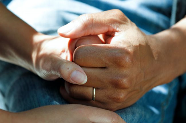 Powiększ zdjęcie: Zdjęcie przedstawia dwie splatające się dłonie. Damską i męską. fot. Licencja CCO/dopena publiczna (National Cancer Institute on Unsplash)