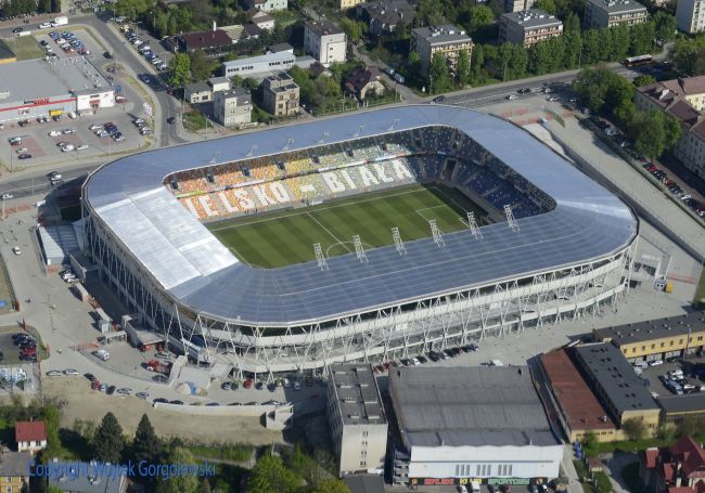 Powiększ zdjęcie: Zdjęcie z lotu ptaka przedstawia stadion miejski w Bielsku-Białej  z budynkami dookoła.     Źródło:  http://www.bbosir.bielsko.pl/obiekt/Stadion-miejski
